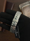 Stainless steel Patek Philippe men's watch bracelet displayed on gloved hand, luxury watch accessory.