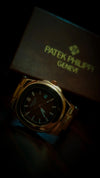 Premium gold Patek Philippe men’s watch with black dial, elegant modern design, luxury box